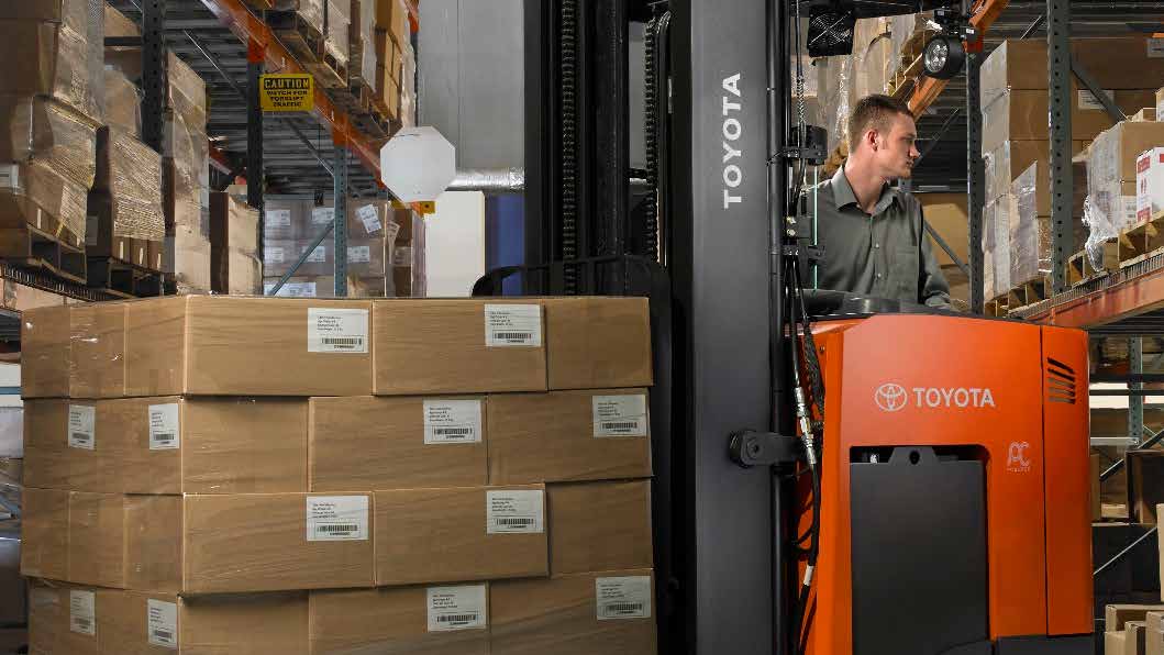 Our featured product, the reach truck, navigating a warehouse aisle with a load.