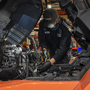 A technician working on a forklift engine
