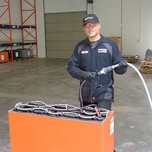 A battery technician using a battery watering system