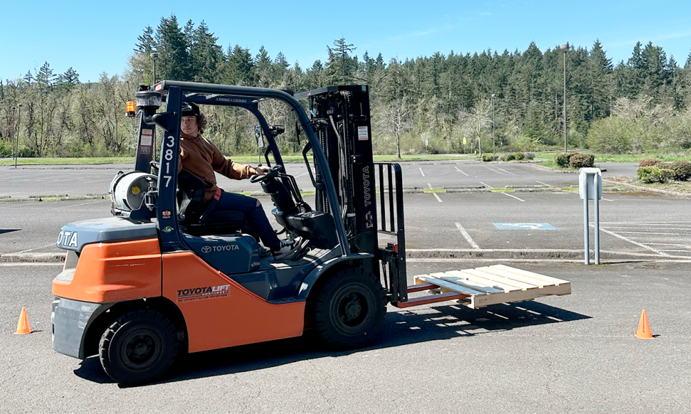 Student at Cottage Grove High School navigates forklift obstacle during training.