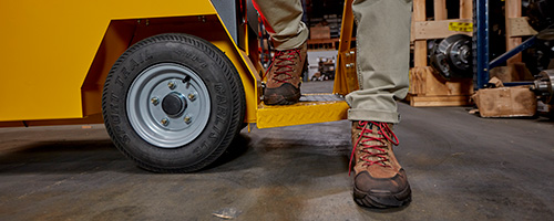 The Taylor-Dunn Stock Chaser's step is low to the ground for easy access and constant disembarking